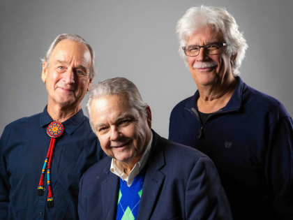Musician sits in profile with guitar resting on lap.